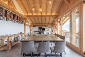 a dining room with a large wooden table and chairs at Les Belles des Champs in Combloux