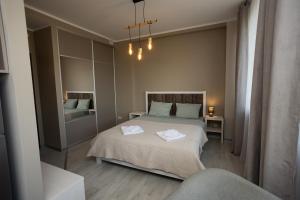 une chambre avec un lit avec deux serviettes dessus dans l'établissement Alejas Apartments, à Rēzekne