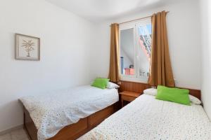 two twin beds in a room with a window at La Bayana Apartaments - 4 in Puerto Naos +20 photos