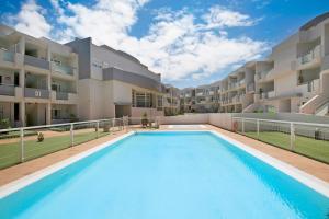 ein großes Schwimmbad vor einem Gebäude in der Unterkunft Garden 128 in Corralejo