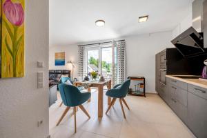 une cuisine avec une table et deux chaises bleues dans l'établissement im Naturpark Rhein-westerwald, à Puderbach