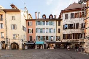 a group of buildings in a street with people walking at Lodges Du Canal St Dominique Annecy in Annecy