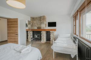 une chambre avec deux lits et une cheminée dans l'établissement Casa Rural Torrecaballeros-Segovia, à Torrecaballeros