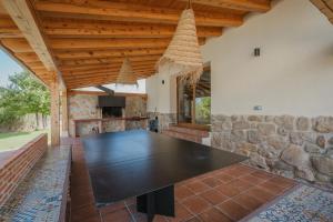 une grande table noire dans une cuisine avec un mur en pierre dans l'établissement Casa Rural Torrecaballeros-Segovia, à Torrecaballeros