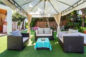 a patio with two couches and a table under a canopy at Villa La bicicleta azul in Málaga
