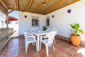 una mesa y sillas en el patio de una casa en Casa Carlos con Piscina Privada en Conil, en Campano