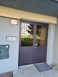 a purple door of a building with a sign on it at Apartmán Sárka Brezno in Brezno