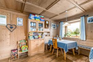 a dining room with a table in a room with wooden walls at Huberhof App Golden Delicious in Feldthurns