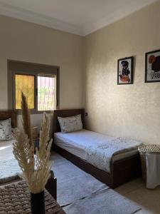 a bedroom with two beds and a window at Oasis apartment in Ouarzazate