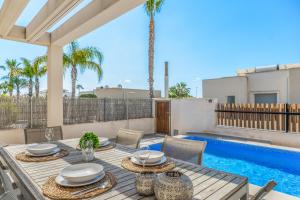 オリフエラ・コスタにあるCasa Imjo Groundfloor private poolのパティオ(テーブル、椅子付)、スイミングプールが備わります。