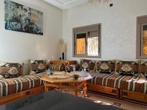 a living room with two couches and a table at Oasis apartment in Ouarzazate
