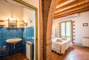 a bathroom with a bed and a sink in a room at Villa Il Fornacino in Rapolano Terme +31 photos