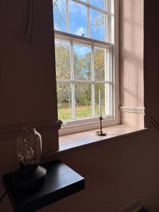 a window with a candle on a table in a room at Little House Harrogate in Harrogate