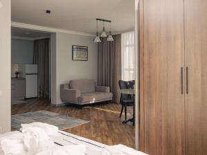 a living room with a couch and a chair at 71 East Apart Hotel in Astana