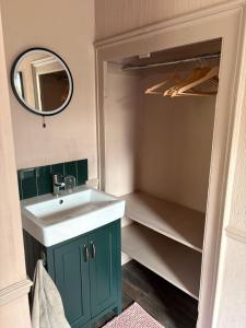 a bathroom with a sink and a mirror and a closet at Little House Harrogate in Harrogate +8 photos
