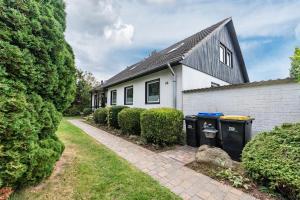 a house with two trash cans in front of it at Zwischen den Wellen in Oldenburg in Holstein