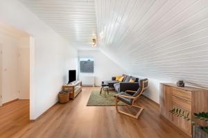 a living room with a large white wall at Zwischen den Wellen in Oldenburg in Holstein