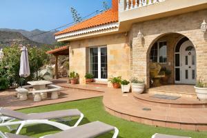 ein Haus mit einer Terrasse mit Stühlen und einem Tisch in der Unterkunft Holiday Home Hemi in Islas Canarias