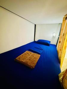 Phumĭ Kâoh RŏngにあるDavid's Hostel & Restaurantの小さな部屋の大きな青いベッド1台