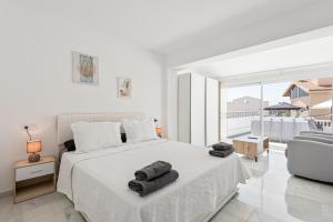 a white bedroom with a large bed and a couch at Villa Pedregalejo Vistas al mar in Málaga +22 photos