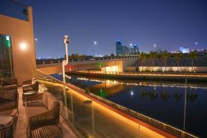 ein Hotelbalkon mit einem Wasserbecken bei Nacht in der Unterkunft Pavilion Hotel Al Jaddaf - Former Citadines Culture Village in Dubai