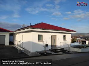 a white house with a red roof at Gästezimmer La Siesta in Ötisheim