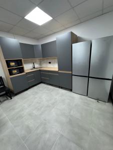 an empty kitchen with stainless steel refrigerators in a room at Хостел "Батискаф" in Bila Tserkva