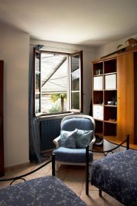 a bedroom with a chair and a window at Tinas yellow home in Leggiuno