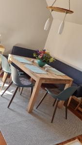 a wooden table with chairs and a vase of flowers on it at Ferienwohnung Rihm in Raduhn +7 photos