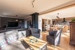 Una sala de estar con un sofá y sillas y una mesa. en Maison Paul, en Bagnères-de-Bigorre