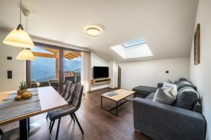 Una sala de estar con un sofá y un comedor. en Sunnseitn Lodge Apt Mountainsuite, en Stulles