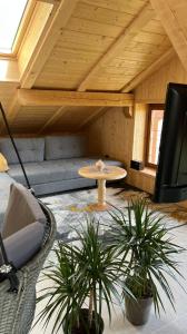 a living room with a couch and a table and plants at Truma Swing Castelfondo in Castelfondo