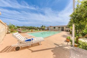 a swimming pool with a white bench next to a house at Dependance con piscina in Taurisano