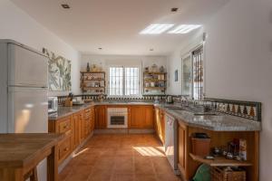 eine große Küche mit Holzschränken und einem weißen Kühlschrank in der Unterkunft Casa Cristina in Jete