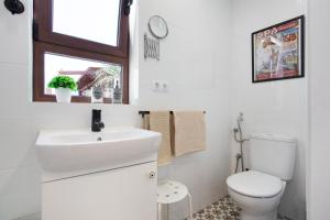 a white bathroom with a sink and a toilet at Alojamiento El Ocaso in Puerto del Rosario +19 photos