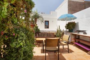 a patio with chairs and a table and an umbrella at Alojamiento El Ocaso in Puerto del Rosario