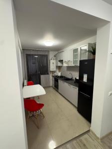 a kitchen with a white table and red chairs at AA home in Craiova International Airport +9 photos