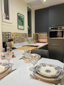 a kitchen with a table with plates and glasses on it at Superbe appartement quartier latin in Paris