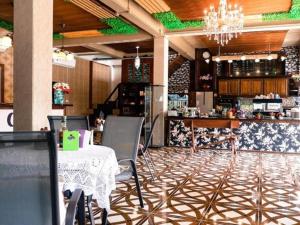 a restaurant with a table and chairs and a bar at Grace Hostel - Chiang Rai in Chiang Rai