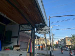 a sign on the side of a store on a street at Grace Hostel - Chiang Rai in Chiang Rai