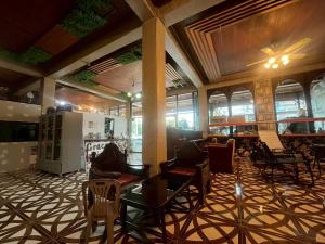 a lobby with chairs and tables in a building at Grace Hostel - Chiang Rai in Chiang Rai