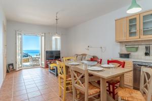 een keuken en eetkamer met een tafel en stoelen bij Sun Blooming Villa In Tinos Island in Agios Romanos