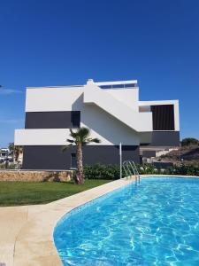 een gebouw met een zwembad voor een gebouw bij Amanecer 7 Alicante in Orihuela