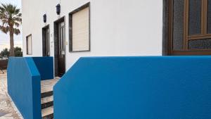 a blue bench in front of a house at Cabo de Sagres -1 bedroom apartment in Sagres