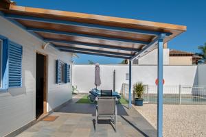 een pergola boven een patio met een tafel bij Casa Azul in Conil de la Frontera