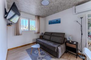 a living room with a couch and a tv at Henriela - Studio 2 personnes in Gujan-Mestras +12 photos