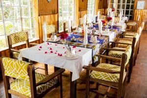 a dining room with tables and chairs with flowers on them at Naro Moru River Lodge in Naro Moru