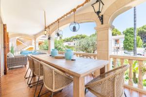 an outdoor patio with a wooden table and chairs at Voramar Alcudia in Alcudia