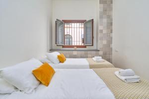 a white bedroom with two beds and a window at Luxury apartment in Nerja in Nerja