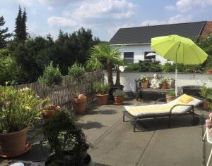eine Terrasse mit einem Stuhl, einem Sonnenschirm und Pflanzen in der Unterkunft Ruhige Ferienwohnung Beletage in Neuwied + 22 Fotos